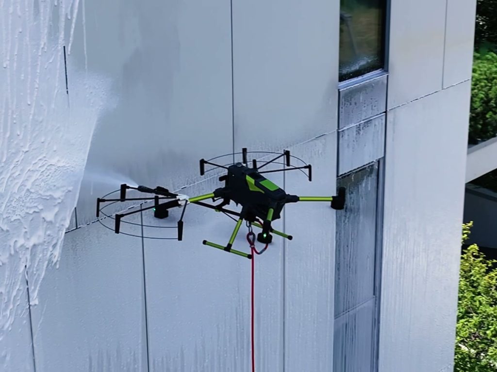 Dron myjący elewację budynku pianą czyszczącą