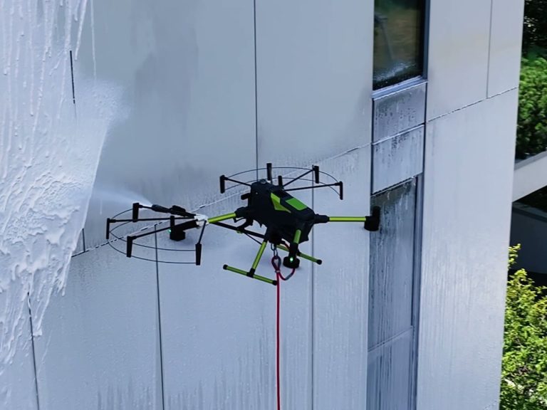 Dron myjący elewację budynku pianą czyszczącą